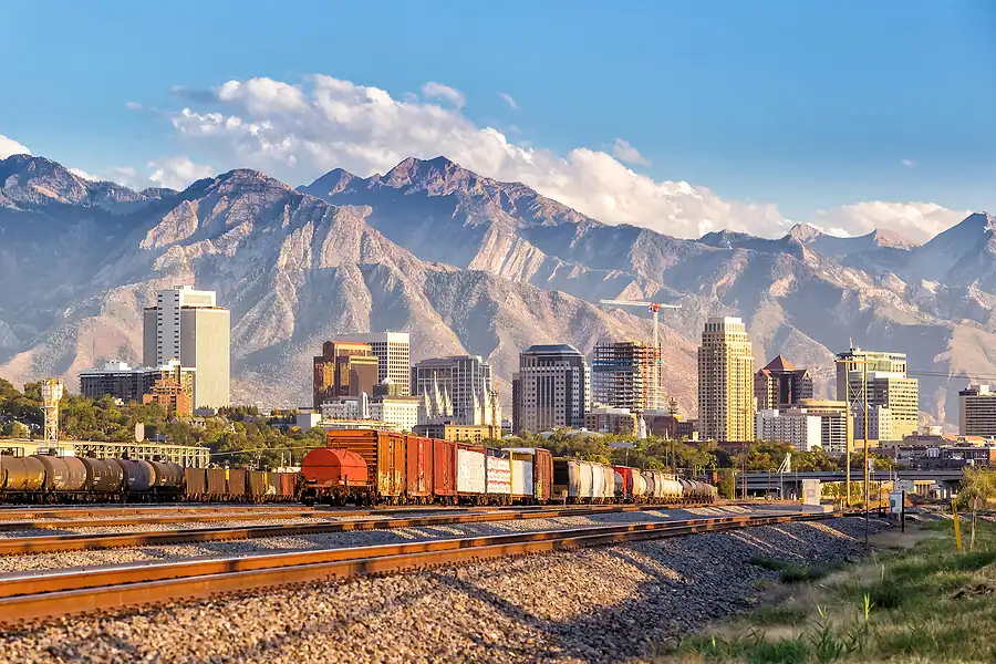 Mountain cityscape with train tracks and urban skyline.